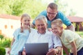 Happy family with grandfather during internet talking on laptop Royalty Free Stock Photo