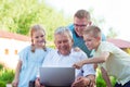 Happy family with grandfather during internet talking on laptop Royalty Free Stock Photo