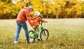 Happy family grandfather teaches child grandson to ride a bike in park Royalty Free Stock Photo