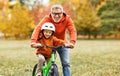Happy family grandfather teaches child grandson  to ride a bike in park Royalty Free Stock Photo
