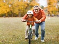 Happy family grandfather teaches child grandson  to ride a bike in park Royalty Free Stock Photo
