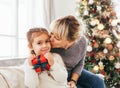 Happy family, grandmother and granddaughter sitting near Christmas tree Royalty Free Stock Photo