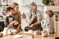 Happy family a grandmother with her daughter and grandchildren cooks in kitchen, kneads dough, bakes cookies Royalty Free Stock Photo