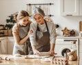 Happy family grandmother old mother mother-in-law and daughter-in-law daughter cook in kitchen, knead dough, bake cookies