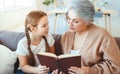 Happy family grandmother reading to granddaughter book at home Royalty Free Stock Photo