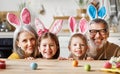 Happy family grandparents and grandchildren having fun while painting Easter eggs together Royalty Free Stock Photo