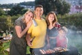 Happy family grilling meat and vegetables on summer day Royalty Free Stock Photo
