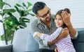 Happy family handsome Asian father, little daughter girl sitting on sofa in cozy living room at home, doing activity together, Royalty Free Stock Photo