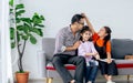 Happy family handsome Asian father, little daughter girls sitting on sofa in cozy living room at home, doing activity together, Royalty Free Stock Photo