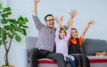 Happy family handsome Asian father, little daughter girls sitting on sofa in cozy living room at home, doing activity together, Royalty Free Stock Photo