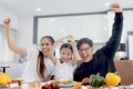 Happy family has meal in dining room. Mother father kid daughter sit at dining table, have fun during breakfast or lunch. Cheerful Royalty Free Stock Photo