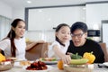 Happy family has meal in dining room. Parents, mother father and kid daughter sit at dining table and have fun during breakfast or Royalty Free Stock Photo