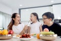 Happy family has meal in dining room. Parents, mother father and kid daughter sit at dining table and have fun during breakfast or Royalty Free Stock Photo