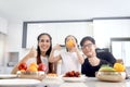 Happy family has meal in dining room. Parents, mother father and kid daughter sit at dining table and have fun during breakfast or Royalty Free Stock Photo