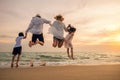 Happy family have fun jumping on beach in holiday at sunset Royalty Free Stock Photo