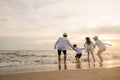 Happy family have fun jumping on beach in holiday at sunset Royalty Free Stock Photo