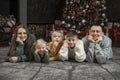 Happy family have fun near Christmas tree. Father, mother and three children at home. Xmas holiday Royalty Free Stock Photo