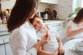 Happy family having breakfast at home. Mother with two kids eating in the morning in modern white kitchen Royalty Free Stock Photo