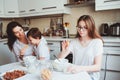 Happy family having breakfast at home. Mother with two kids eating in the morning in modern white kitchen Royalty Free Stock Photo