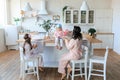 Happy family having breakfast together, modern kitchen. Smiling mother pouring cereal into bowl daugter, eat snack. Healthy food Royalty Free Stock Photo