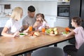 Happy family having breakfast together at table in modern kitchen Royalty Free Stock Photo