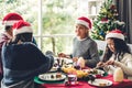 Happy family are having dinner with tasty food and wine glasses with christmas decoration on the christmas themed dinner table at Royalty Free Stock Photo