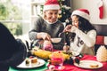 Happy family are having dinner with tasty food and wine glasses with christmas decoration on the christmas themed dinner table at