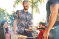 Happy family having fun at barbecue party - Chef senior man grilling and serving meat Royalty Free Stock Photo