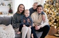 Happy family having fun in bedroom. Cheerful young family with kids sitting on sofa, embracing and laughing Royalty Free Stock Photo