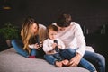 Happy family is having fun in bedroom. Enjoying being together. Parents are tickling their little son while lying in bed Royalty Free Stock Photo