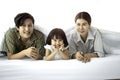 Happy family having fun in the bedroom. Father, mother and daughter lying on bed and spending time together, parents and kid Royalty Free Stock Photo