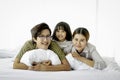 Happy family having fun in the bedroom. Father, mother and daughter lying on bed and spending time together, parents and kid Royalty Free Stock Photo