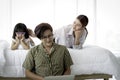 Happy family having fun in the bedroom. Father using laptop computer for working at home or shopping online, mother and daughter