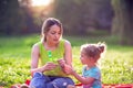 Happy family having fun- child blows soup foam and make bubbles with her mother in nature Royalty Free Stock Photo