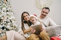 Happy family having fun on digital tablet in bed on Christmas Royalty Free Stock Photo