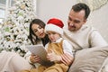 Happy family having fun on digital tablet in bed on Christmas Royalty Free Stock Photo