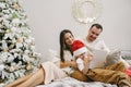 Happy family having fun on digital tablet in bed on Christmas Royalty Free Stock Photo