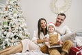 Happy family having fun on digital tablet in bed on Christmas Royalty Free Stock Photo