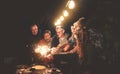 Happy family having fun at dinner night party outdoor - Group of people mixed ages celebrating together with fireworks sparklers Royalty Free Stock Photo