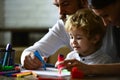 Happy family having fun draw together at a home, parents and little child playing together. Cheerful son with father and Royalty Free Stock Photo