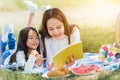 Happy family having fun and enjoying outdoor laying on picnic blanket reading book Royalty Free Stock Photo