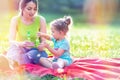 Happy family having fun- Female child blows soup foam and make bubbles in nature