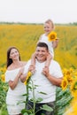 Happy family having fun in the field of sunflowers. Father holding his daughter. baby girl holding sunflower. outdoor shot Royalty Free Stock Photo