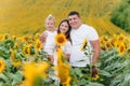 Happy family having fun in the field of sunflowers. Mother holding her daughter and sunflower in hand. The concept of summer Royalty Free Stock Photo