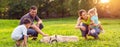 happy family is having fun with golden retriever - family playing with dog in park. Royalty Free Stock Photo