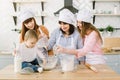 Happy family having fun in the kitchen. Grandmother and her daughters and little baby girl kneading dough together in Royalty Free Stock Photo