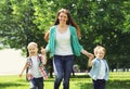 Happy family is having fun, mother playing with two children sons running on the grass in summer park on a sunny day Royalty Free Stock Photo