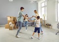 Happy joyful family dancing and having fun in their new spacious apartment on moving day Royalty Free Stock Photo