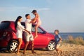 Happy family having fun near car on sandy beach. Summer trip Royalty Free Stock Photo