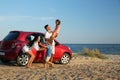 Happy family having fun near car on sandy beach. Summer trip Royalty Free Stock Photo